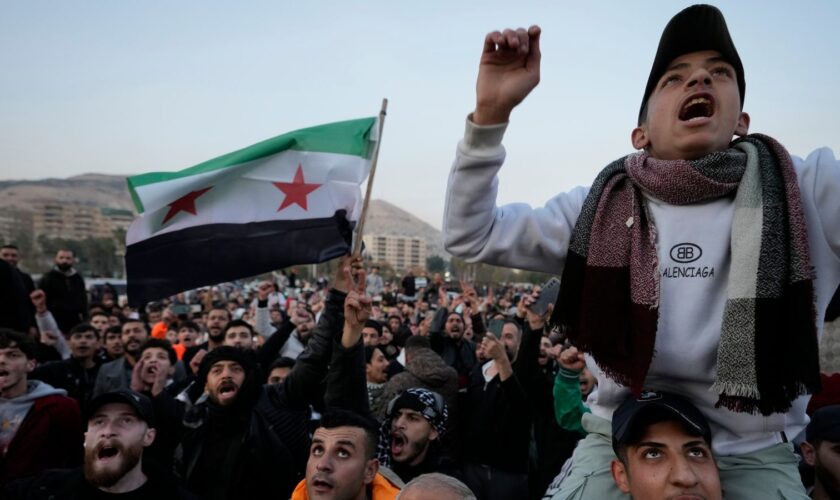 Syrian citizens wave the revolutionary flag and shout slogans as they celebrate during the second day of the take over of the city by the insurgents in Damascus, Syria, Monday, Dec. 9, 2024. (AP Photo/Hussein Malla)