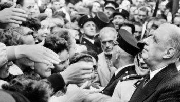 le général de Gaulle serre de nombreuses mains sur le parcours entre l'aérodrome et Rennes, où il vient, le 20 septembre 1958, présenter le projet de la nouvelle Constitution et inciter les Français à voter "OUI" au réferendum du 28 septembre 1958. Ce réferendum donnera naissance à la Vème République. La nouvelle Constitution qui réduit le pouvoir du Parlement et renforce celui du président, qui sera désormais élu au suffrage universel, a été approuvée à 82,60 % des suffrages exprimés.