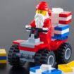 Tambov, Russian Federation - October 04, 2013 Lego Santa Claus minifigure on red quadrocycle with gift boxs on black background. Studio shot. LEGO is a popular line of construction toys manufactured by the Lego Group (Billund, Denmark).