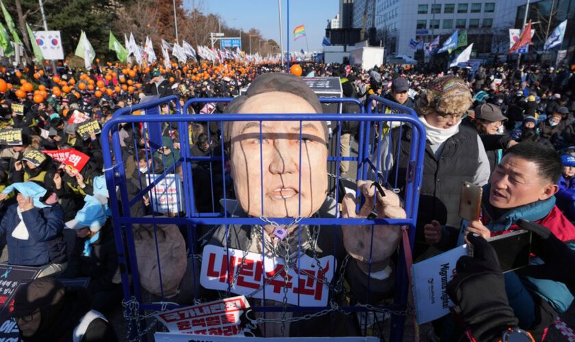 A caricature of South Korea's president is seen behind bars as protesters gathered to demand his impeachment today. Pic: AP