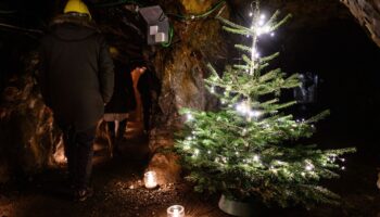 Besucher gehen über den Weihnachtsmarkt unter Tage. Foto: Swen Pförtner/dpa