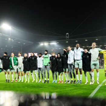 Rundum zufrieden: Werder Bremen feiert nach einem souveränen Sieg in St. Pauli mit den eigenen Fans. Foto: Christian Charisius/d