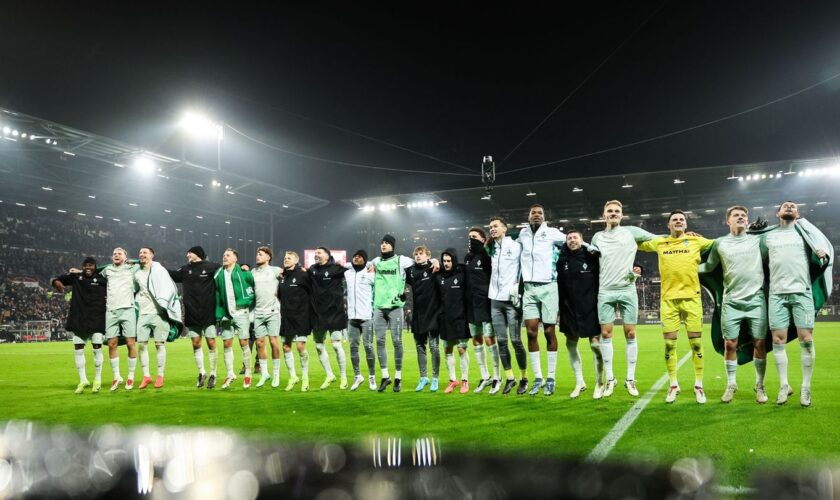 Rundum zufrieden: Werder Bremen feiert nach einem souveränen Sieg in St. Pauli mit den eigenen Fans. Foto: Christian Charisius/d