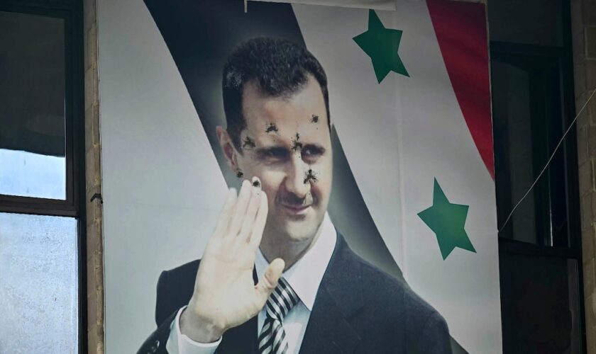 Un poster du président syrien déchu Bachar al-Assad criblé de balles, le 12 dcéembre 2024 à Alep, dans le nord de la Syrie