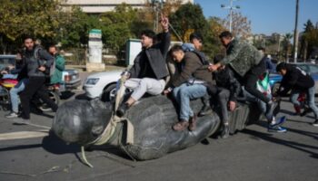 Studenten auf einer Statue des Ex-Präsidenten Hafis al-Assad