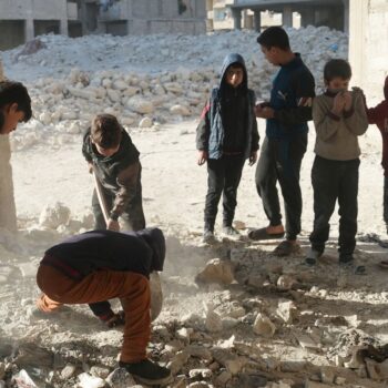 Children dig up bones where at least 41 murdered in Syria pit massacre