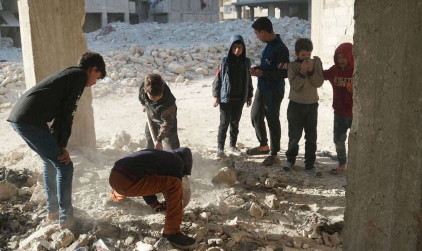 Children dig up bones where at least 41 murdered in Syria pit massacre