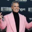 Popstar Robbie Williams im rosa Mantel bei der Premiere seines Films in Köln