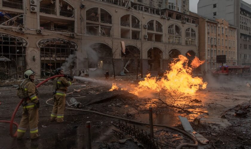 Des soldats ukrainiens tentent d'éteindre un feu après une frappe russe à Kiev, le 20 décembre 2024.