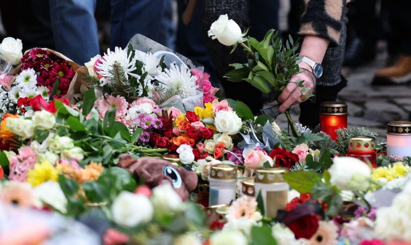 Menschen gedenken der Toten und Verletzten nach der Todesfahrt in Magdeburg. Foto: Jan Woitas/dpa