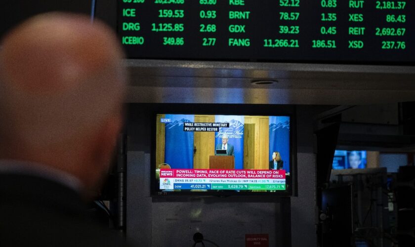 Un écran de télévision diffuse sur le parquet de la Bourse de New York (NYSE) à New York, le 23 août 2024, le discours du président de la Fed, Jerome Powell, à Jackson Hole, dans le Wyoming