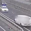 Moment drunk driver crawls at snail's pace the wrong way down the busy A55 before being intercepted by police and hauled onto the carriageway by an officer