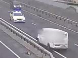 Moment drunk driver crawls at snail's pace the wrong way down the busy A55 before being intercepted by police and hauled onto the carriageway by an officer