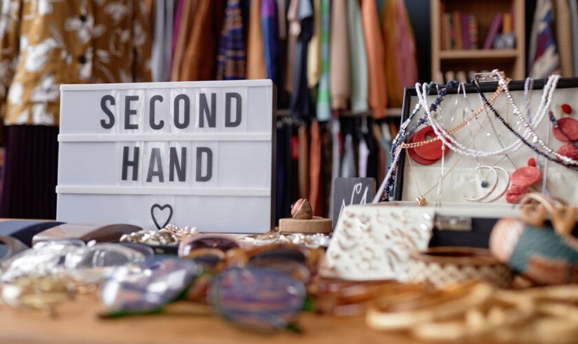 Close up on sign with inscription Second Hand and jewellery case with vintage accessories at thrift store checkout, copy space Pic: iStock