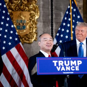 PALM BEACH, FLORIDA - DECEMBER 16: SoftBank CEO Masayoshi Son (C), accompanied by U.S. President-elect Donald Trump (R) and Trump's choice for Secretary of Commerce, Cantor Fitzgerald Chairman and CEO Howard Lutnick (L), speaks at a news conference at Trump's Mar-a-Lago resort on December 16, 2024 in Palm Beach, Florida. In a news conference that went over an hour, Trump announced that SoftBank will invest over $100 billion in projects in the United States including 100,000 artificial intelligence related jobs and then took questions on Syria, Israel, Ukraine, the economy, cabinet picks, and many other topics. Andrew Harnik/Getty Images/AFP (Photo by Andrew Harnik / GETTY IMAGES NORTH AMERICA / Getty Images via AFP)