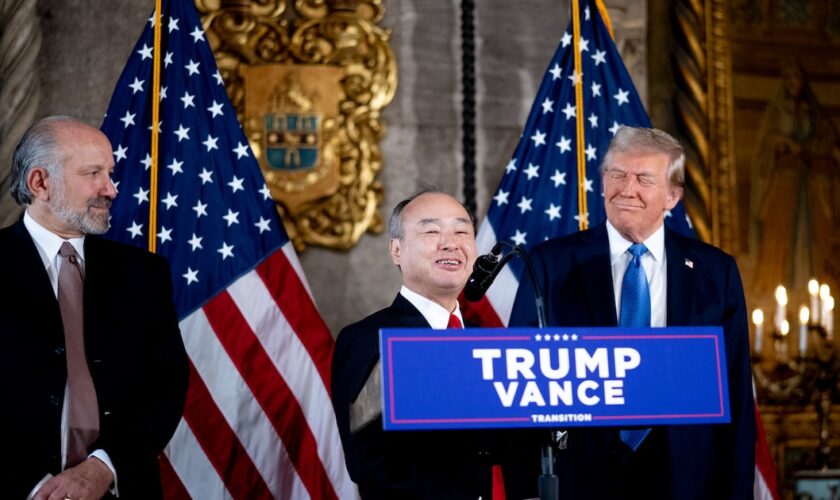 PALM BEACH, FLORIDA - DECEMBER 16: SoftBank CEO Masayoshi Son (C), accompanied by U.S. President-elect Donald Trump (R) and Trump's choice for Secretary of Commerce, Cantor Fitzgerald Chairman and CEO Howard Lutnick (L), speaks at a news conference at Trump's Mar-a-Lago resort on December 16, 2024 in Palm Beach, Florida. In a news conference that went over an hour, Trump announced that SoftBank will invest over $100 billion in projects in the United States including 100,000 artificial intelligence related jobs and then took questions on Syria, Israel, Ukraine, the economy, cabinet picks, and many other topics. Andrew Harnik/Getty Images/AFP (Photo by Andrew Harnik / GETTY IMAGES NORTH AMERICA / Getty Images via AFP)