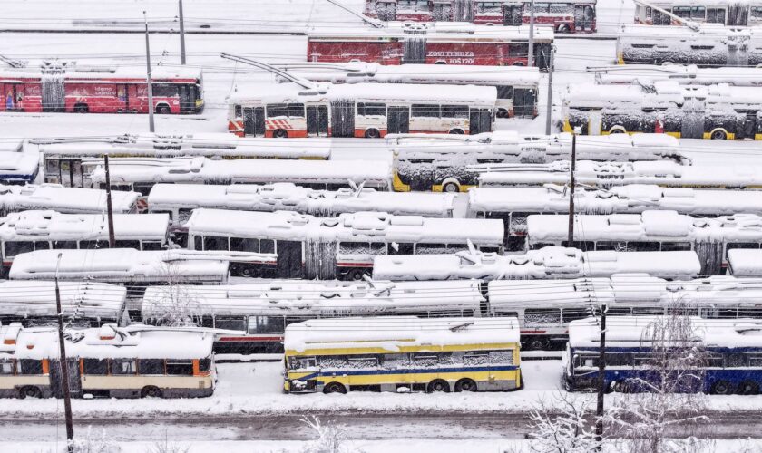 An aerial view of parked trolley buses during heavy snowfall in Sarajevo, Bosnia, Tuesday, Dec. 24, 2024. (AP Photo/Armin Durgut)