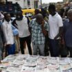 Des habitants du quartier d'Ikeja à Lagos regardent les unes des journaux après la présidentielle, le 27 février 2023