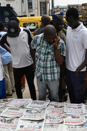 Des habitants du quartier d'Ikeja à Lagos regardent les unes des journaux après la présidentielle, le 27 février 2023