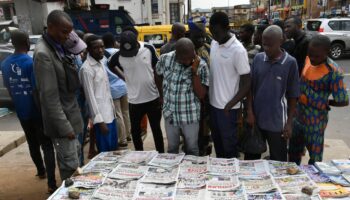 Des habitants du quartier d'Ikeja à Lagos regardent les unes des journaux après la présidentielle, le 27 février 2023