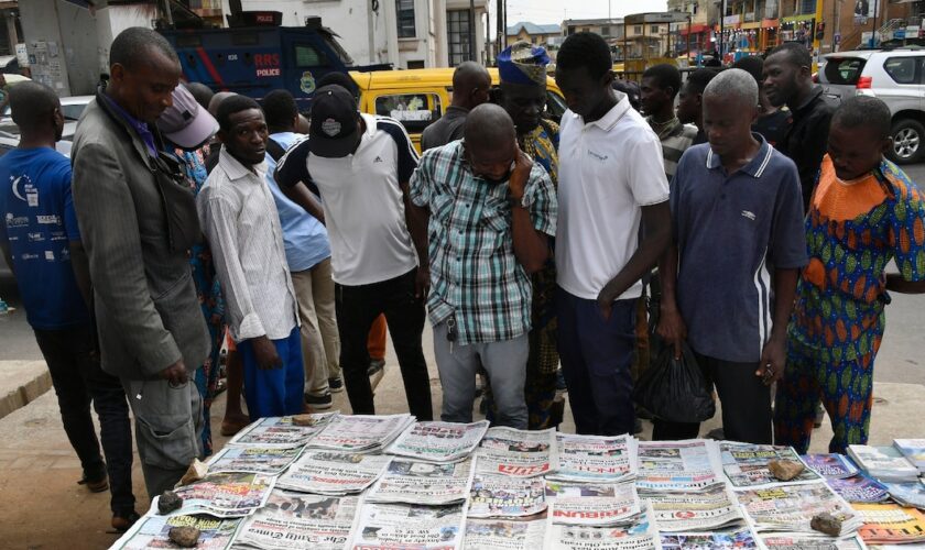 Des habitants du quartier d'Ikeja à Lagos regardent les unes des journaux après la présidentielle, le 27 février 2023