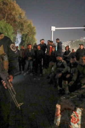 Security forces of the new Syrian government secure the area around group of Alawite protesters in the Mazzeh district in Damascus. Pic: AP