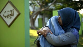 Women comfort each other as they visit a mass grave of victims of the 2004 Indian Ocean tsunami in Banda Aceh, Indonesia. Pic: AP