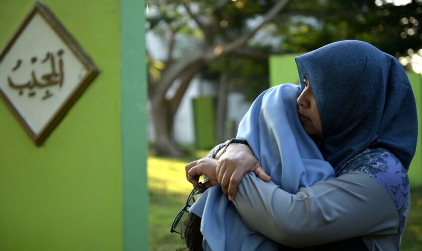 Women comfort each other as they visit a mass grave of victims of the 2004 Indian Ocean tsunami in Banda Aceh, Indonesia. Pic: AP