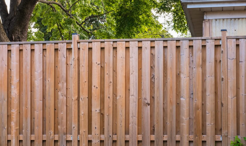 Certains jardiniers font un trou en bas de leur clôture - ce geste méconnu est pourtant très utile