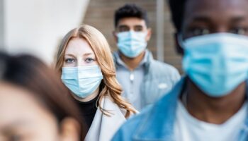 Authentic shot of multiracial people in the city wearing face mask and walking on the pavement commuting to work - Lifestyle and health issues concepts