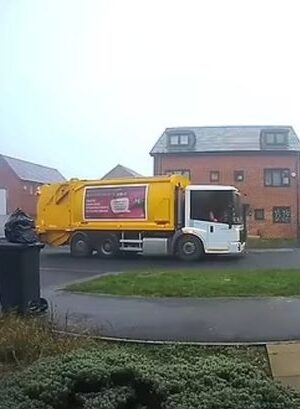 Moment binman removes rubbish bag from top of bin and dumps it on ground in Christmas collection