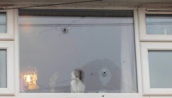 Photos show home's window riddled with bullet holes after 'gunman on bike' opens fire