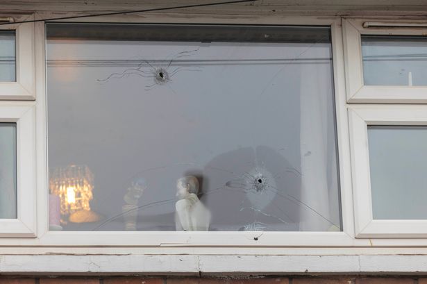 Photos show home's window riddled with bullet holes after 'gunman on bike' opens fire