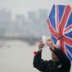 File photo dated 13/08/15 of a man's umbrella blowing inside out as he take a photo with his mobile phone in Westminster, London. Pic: PA