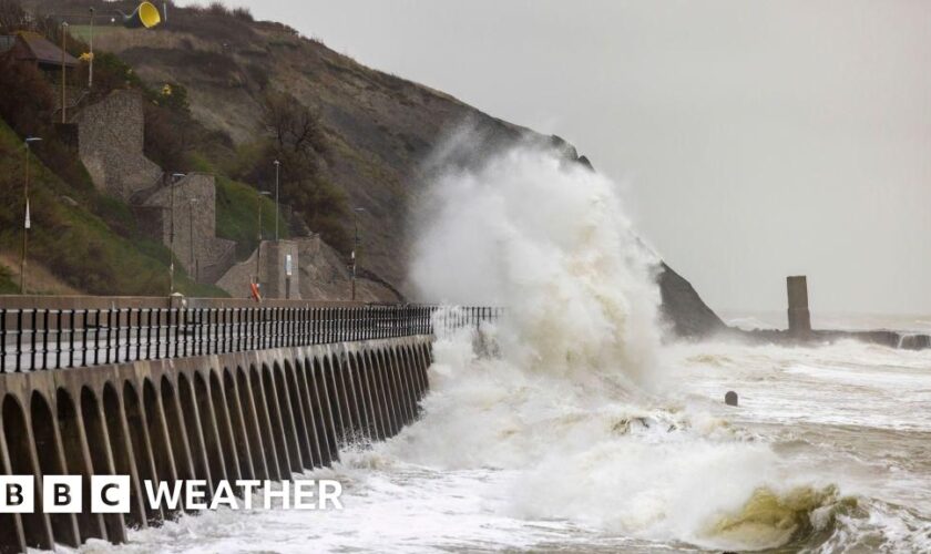 A waves crashing over a sea defence promenade during a storm