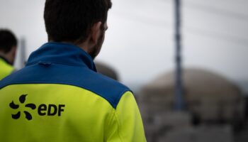 Un salarié d'EDF en face d'une coupole de la centrale nucléaire de Flamanville dans la Manche, le 25 avril 2024 (ARCHIVE)