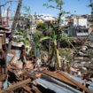 Des enfants au milieu des maisons détruites d'un bidonville endommagé par le cyclone Chido à Mamoudzou, sur le territoire de Mayotte, le 31 décembre 2024